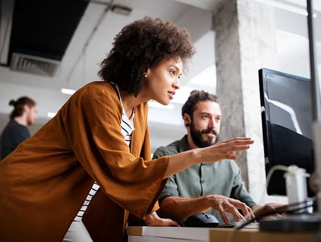 Two people analyzing a screen 