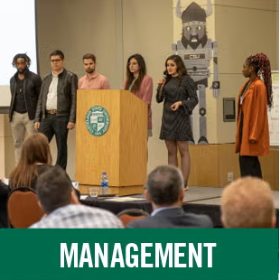 Management students presenting at a podium 