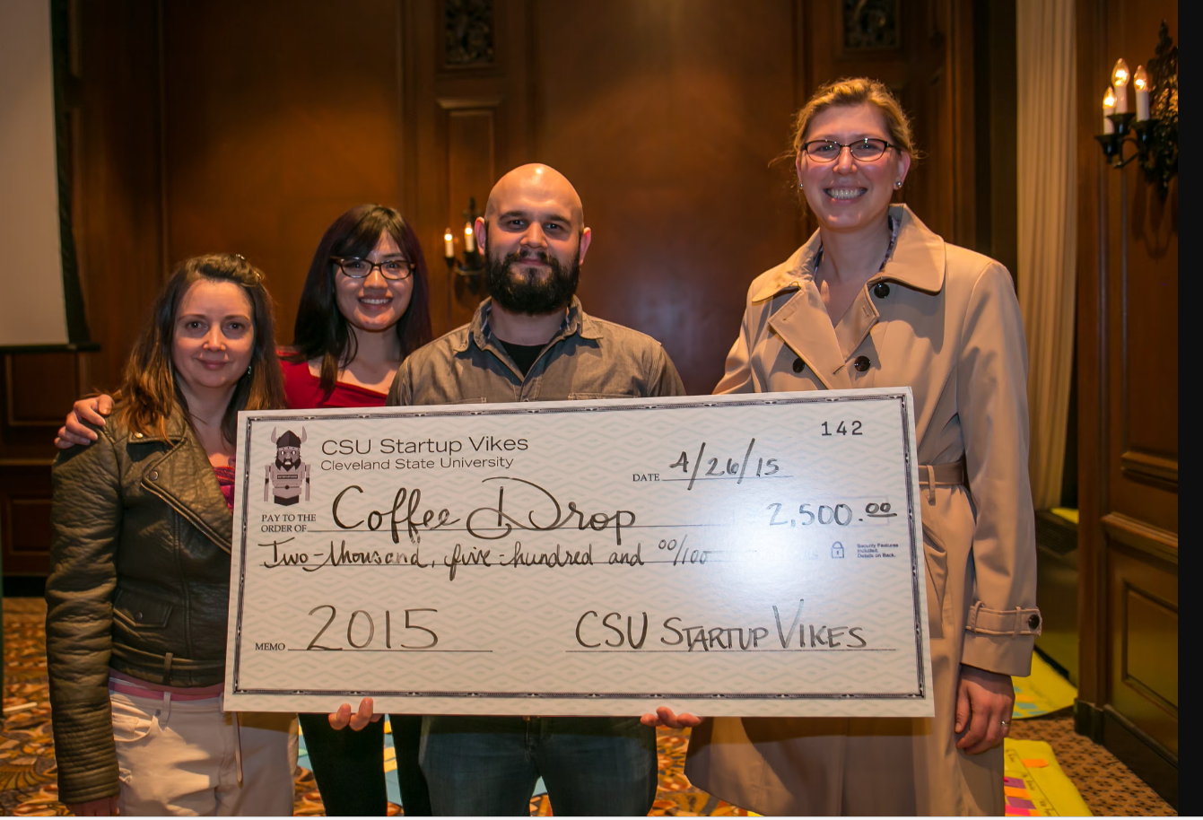 Team Coffee Drop holding large prize check 