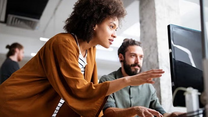 Two people analyzing a screen 