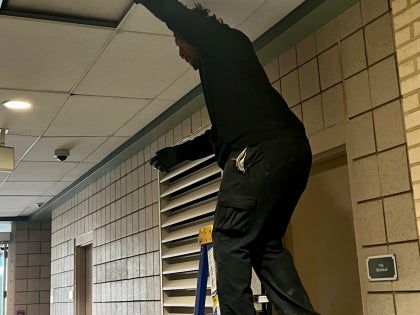 Construction worker on a ladder in 1st floor hallway